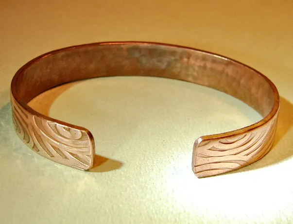 Swirling design on a cuff bracelet in heavy copper