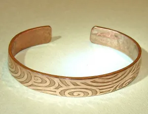 Swirling design on a cuff bracelet in heavy copper